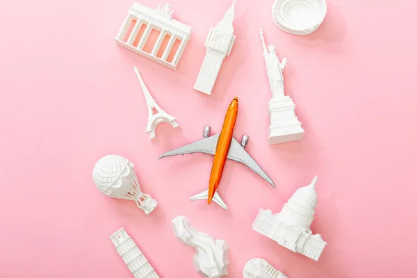 Ansicht von Spielzeugflugzeug in der Nähe von Figuren aus Ländern auf rosa — Stockfoto