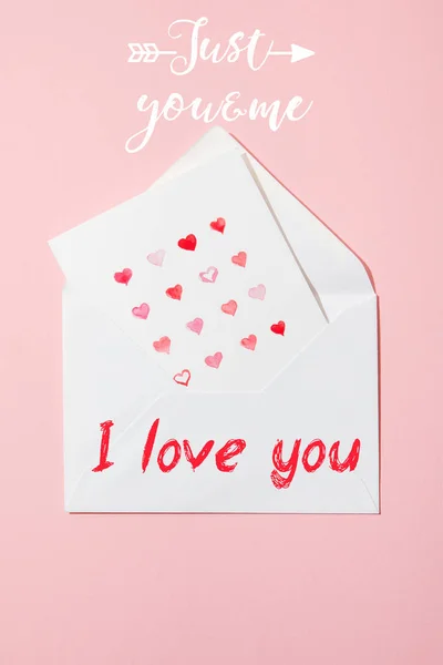 Top view of greeting card with hearts in white envelope with i love you lettering on pink — Stock Photo