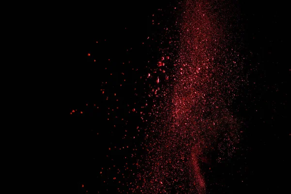 Rojo colorido holi pintura explosión sobre fondo negro - foto de stock