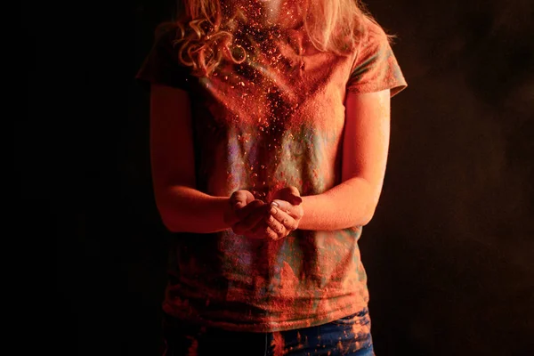 Cropped view of woman with orange colorful holi paint powder isolated on black — Stock Photo