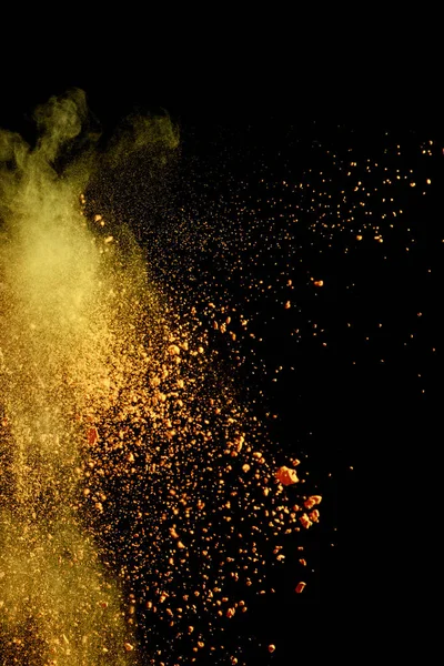 Jaune coloré holi peinture explosion sur fond noir — Photo de stock