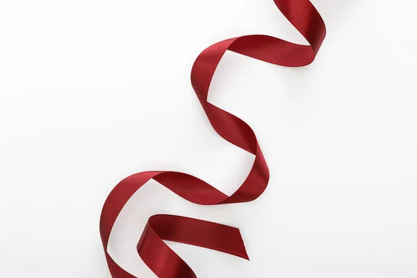 Top view of satin burgundy decorative curved ribbon isolated on white — Stock Photo