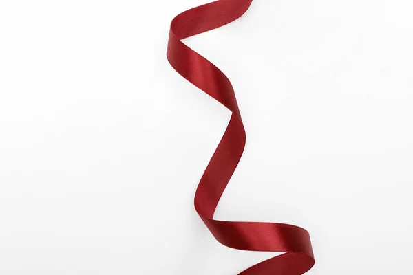 Top view of satin burgundy decorative curved ribbon isolated on white — Stock Photo