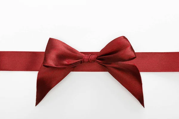 Top view of satin burgundy decorative ribbon with bow isolated on white — Stock Photo