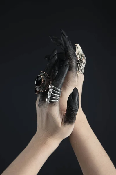 Cropped view of hands of witch with jewelry rings and black dye isolated on black — Stock Photo