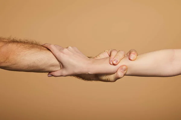 Vista ritagliata di uomo e donna che si tengono le mani isolate sul beige — Foto stock