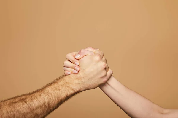 Recortado vista de hombre y mujer brazo lucha aislado en beige - foto de stock