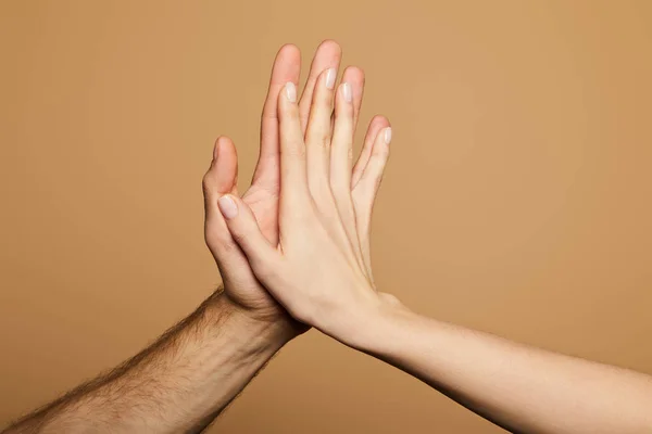 Cropped view of man and woman giving high five isolated on beige — Stock Photo