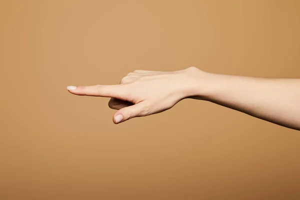 Обрезанный вид женщины, указывающей пальцем на бежевый цвет — стоковое фото