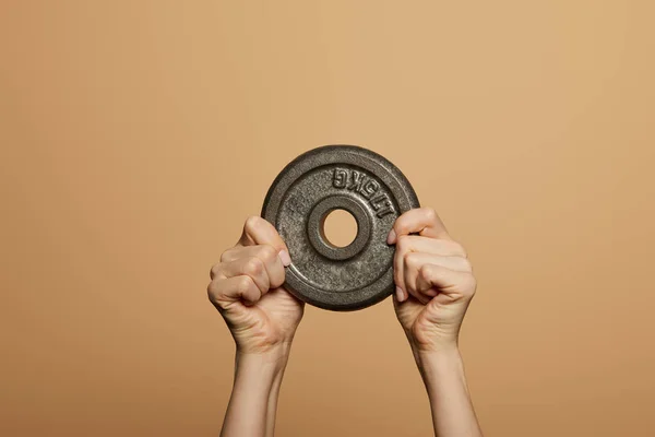 Cropped view of woman holding weight isolated on beige — Stock Photo