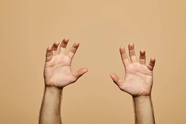 Cropped view of man showing palms isolated on beige — Stock Photo