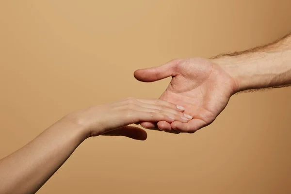 Abgeschnittene Ansicht eines Mannes, der die Hand der Frau isoliert auf Beige hält — Stockfoto