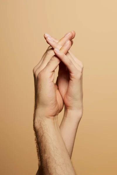 Vue recadrée de l'homme et de la femme tenant les mains isolées sur beige — Photo de stock