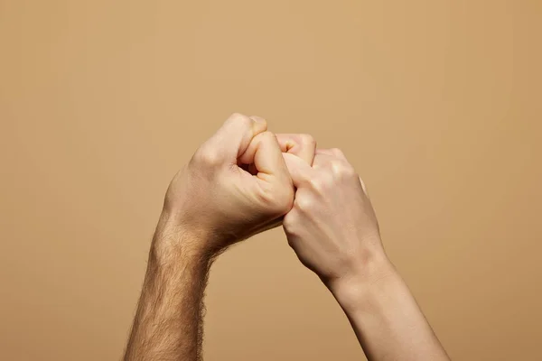 Vue partielle de l'homme et de la femme tenant les mains et les doigts isolés sur beige — Photo de stock