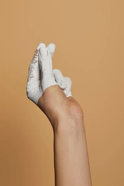 Cropped view of woman with white painted hand sowing money gesture isolated on beige — Stock Photo