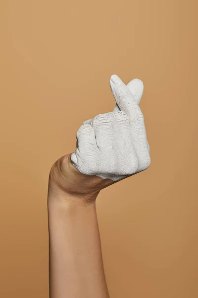 Обрізаний вид жінки з білою пофарбованою рукою ізольовано на бежевому — стокове фото