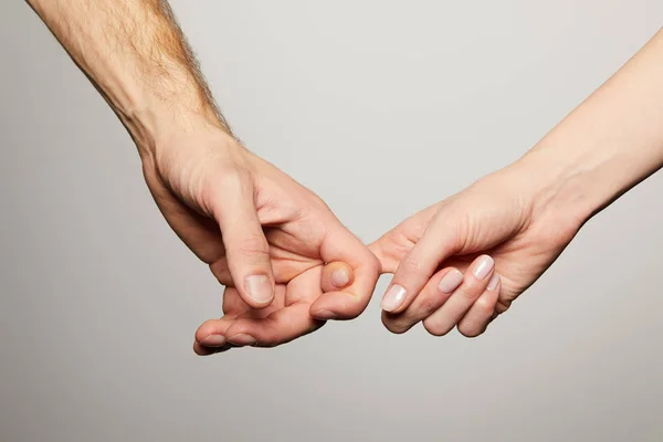 Vue recadrée de l'homme et de la femme tenant les doigts isolés sur blanc — Photo de stock