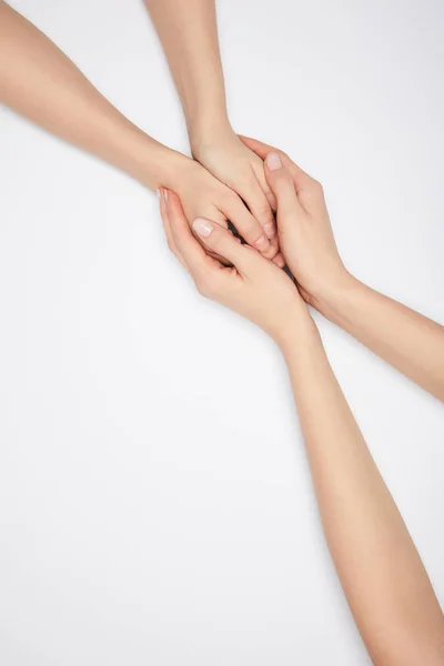 Vista superior de dos mujeres cogidas de la mano aisladas en blanco - foto de stock