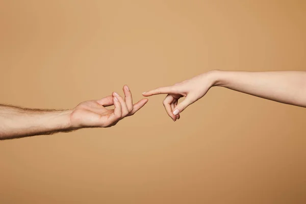 Cropped view of man and woman reaching each other with fingers isolated on beige — Stock Photo