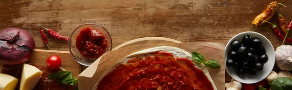 Vista dall'alto di pizza e ingredienti su fondo di legno, colpo panoramico — Foto stock