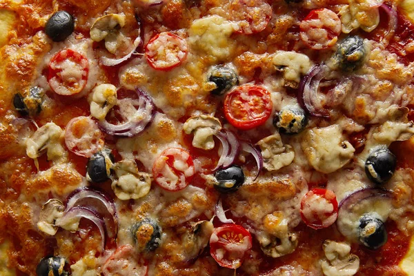 Vue du dessus d'une délicieuse pizza aux tomates cerises, aux olives et au parmesan — Photo de stock