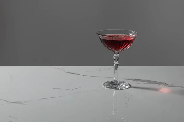 Vaso con vino tinto sobre superficie de mármol aislado sobre gris - foto de stock