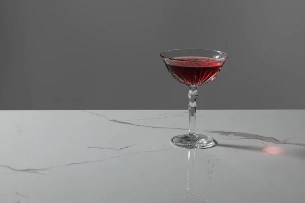 Vaso con vino tinto sobre superficie de mármol aislado sobre gris — Stock Photo