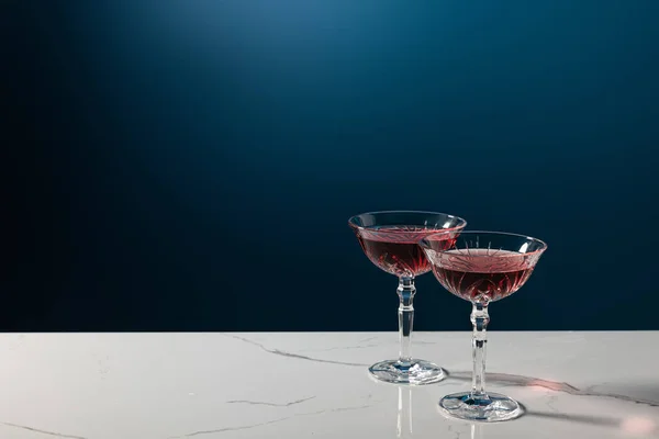 Copos com vinho tinto na superfície de mármore isolado em azul — Fotografia de Stock