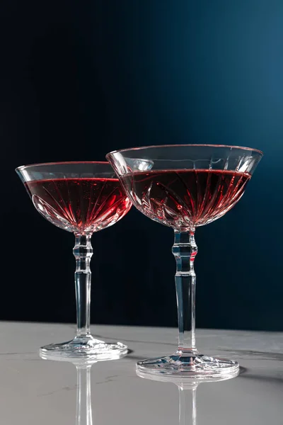 Red wine in glasses on marble surface isolated on blue — Stock Photo