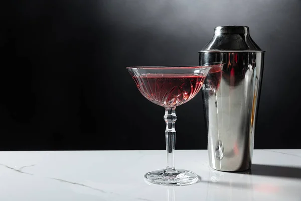 Verre de vin rouge près shaker sur noir avec de la fumée — Photo de stock