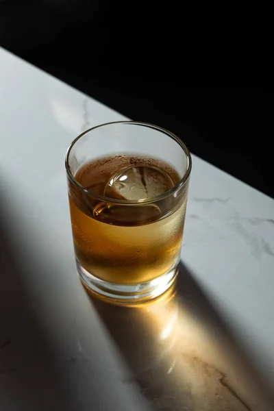 Cubo de hielo en vaso de whisky fuerte aislado en negro - foto de stock