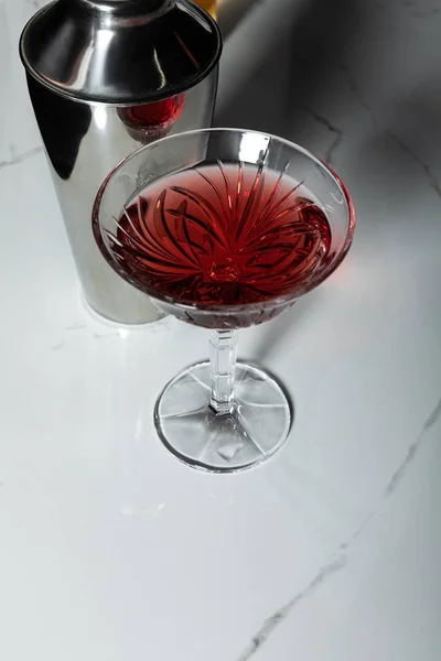 Shaker in der Nähe von Glas mit Rotwein auf Marmoroberfläche — Stockfoto
