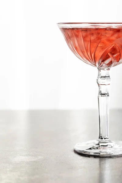 Cocktail rosso con cubetti di ghiaccio in vetro isolato su bianco — Foto stock