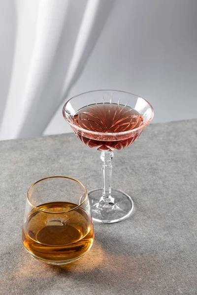 Vin rouge près du verre de cognac sur blanc — Photo de stock