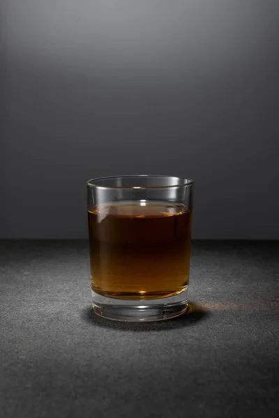 Alcohol drink in glass on grey background — Stock Photo