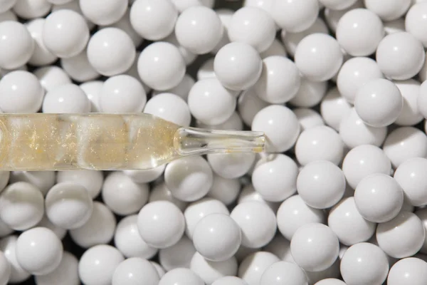 Top view of decorative beads and ampoule with oil — Stock Photo