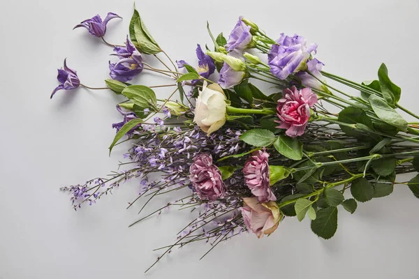 Vista dall'alto del mazzo di fiori viola su sfondo bianco — Foto stock