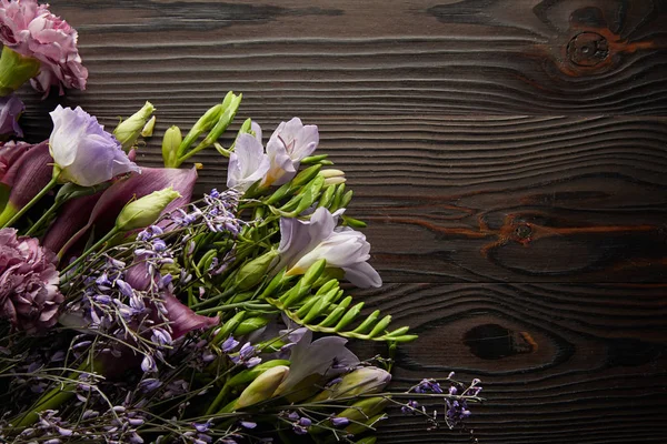 Top view of violet and purple floral bouquet on wooden table — Stock Photo