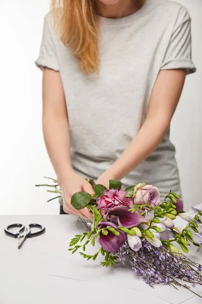 Vista recortada de florista haciendo ramo violeta aislado en blanco - foto de stock