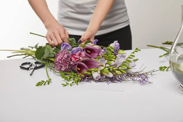 Vista recortada de florista haciendo ramo violeta aislado en blanco - foto de stock