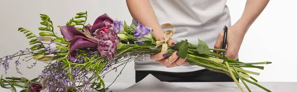 Cropped view of florist cut violet bouquet with scissors isolated on white, panoramic shot — Stock Photo