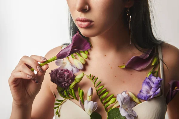Vue recadrée de fille en soutien-gorge avec des fleurs violettes et violettes sur le corps isolé sur blanc — Photo de stock