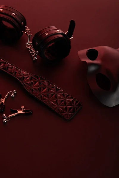 Sexspielzeug in dunkler Beleuchtung auf rotem Hintergrund — Stockfoto