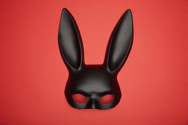 Вид зверху чорна маска для кролика ізольована на червоному — стокове фото