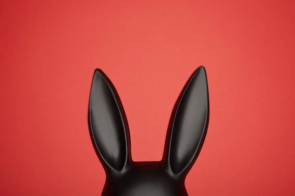 Вид зверху чорна маска для кролика ізольована на червоному — стокове фото