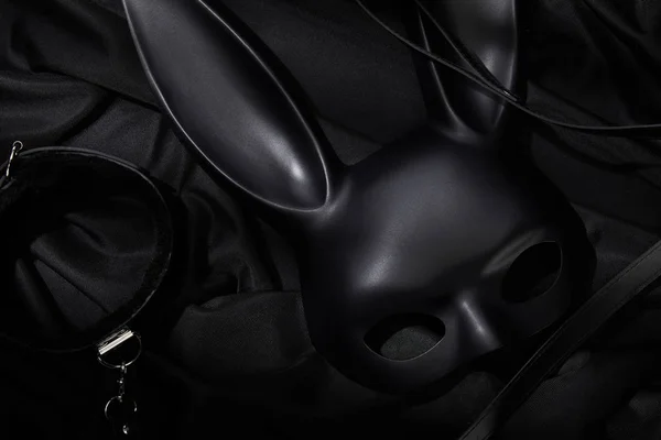 Vue du haut du col et du masque de lapin sur fond textile noir — Photo de stock