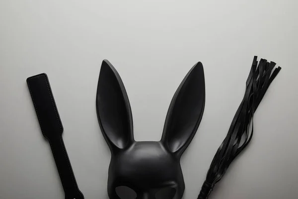 Vista dall'alto della maschera di coniglio nero e giocattoli del sesso su sfondo bianco — Foto stock