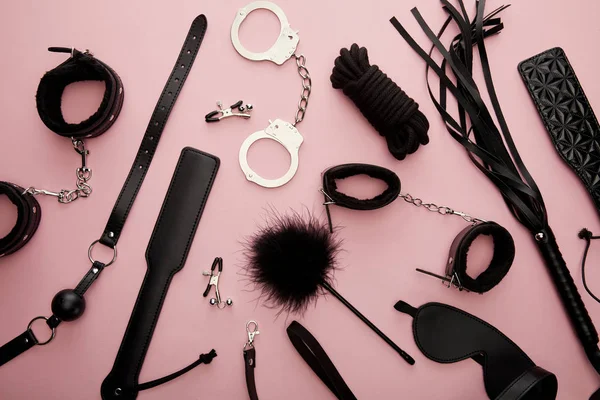 Vue supérieure de jouets sexuels noirs sur fond rose — Photo de stock