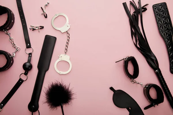 Вид черных секс-игрушек на розовом фоне — стоковое фото