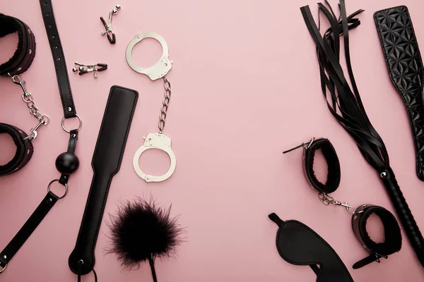 Top view of black sex toys on pink background — Stock Photo